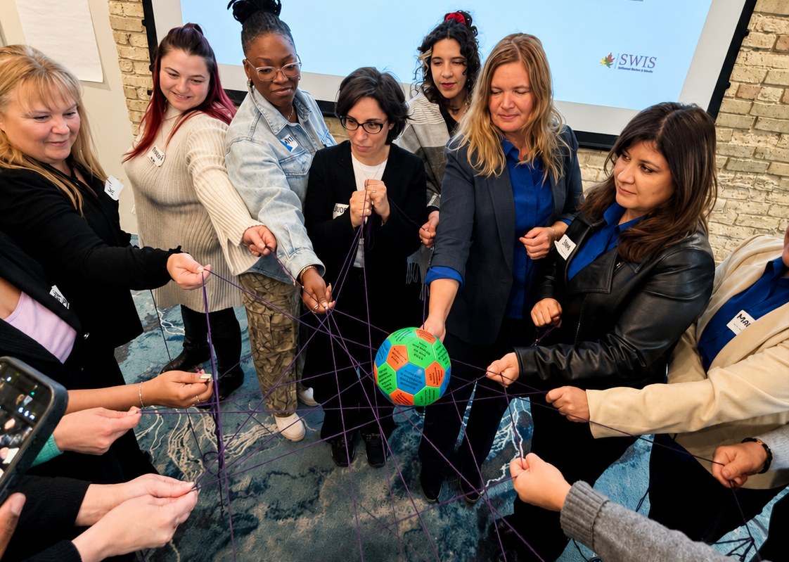 SWIS workers connected by a web of yarn during a regional coordination training session